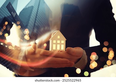 Real estate agent holding toy house - Powered by Shutterstock