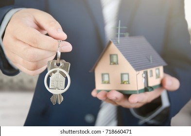 Real Estate Agent With Home Keys And House Miniature. Realestate Key Apartment Real Estate Home House Homeowner Concept