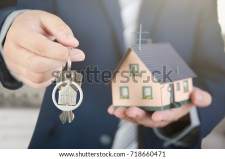 Real estate agent with home keys and house miniature. realestate key apartment real estate home house homeowner concept