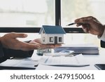 Real estate agent home sales broker holding calculator and pointing to the house model and explains the business contract, rent, buy, mortgage, loan or home insurance.