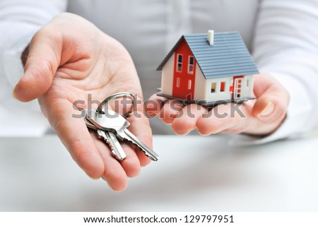 Real estate agent with house model and keys