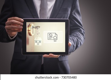 Real Estate Agent Man Showing Keys On Tablet