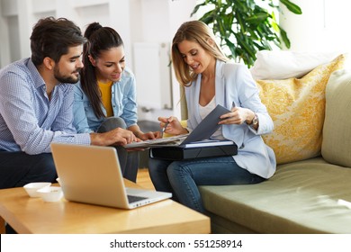 Real Estate agent offer home ownership and life insurance to young couple. - Shutterstock ID 551258914