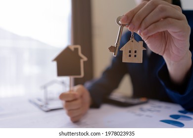 Real estate agent sales manager holding keys to customer and holding sign house offer for and house insurance.home owner, rental property purchase, mortgage investment loan, ownership concept. - Shutterstock ID 1978023935