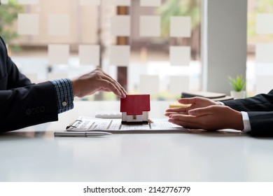 Real estate agent sales manager giving house model to customer after signing rental lease contract of sale purchase agreement, concerning mortgage loan offer for and house insurance. - Shutterstock ID 2142776779