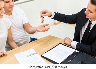 real estate agent is selling an apartment to a young family. conclusion of a lease and purchase of a house, apartment. man shows housing - Shutterstock ID 1606985578