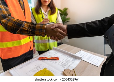 Real Estate Agent Shakes Hands With Construction Team Leader. Business Agrees To Sign A Home Builder After Engineer Shows Model Building Project. Mortgage, Rent, Buy, Sell, Purchase,move,Selling Home.