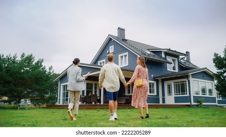 Real Estate Agent Showing a Beautiful Big House to a Young Successful Couple. People Standing Outside on a Warm Day on a Lawn, Talking with Businesswoman, Discussing Buying a New Home.