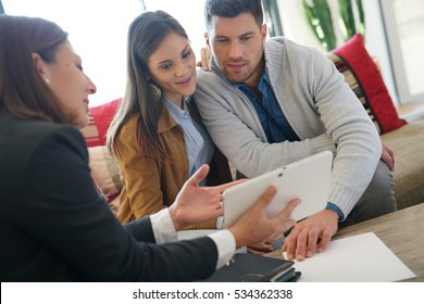 Real Estate Agent Showing House Project On Tablet To Clients