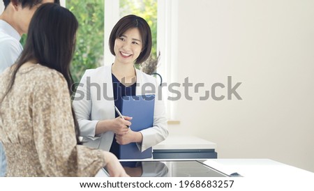 Real estate agent showing house interior for asian couple.