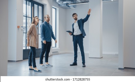 Real Estate Agent Showing a New Empty Office Space to Young Male and Female Hipsters. Entrepreneurs Meet the Broker with a Tablet and Discuss the Facility They Wish to Purchase or Rent. - Shutterstock ID 1712828755