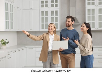 Real estate agent showing new apartment to couple - Powered by Shutterstock