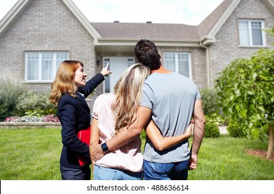 Real Estate Agent Woman With Clients Near New House.