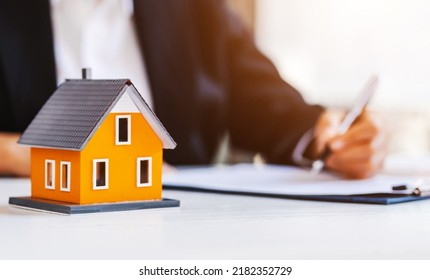 Real Estate Agent Working Sign Agreement Document Contract For Home Loan Insurance Approving Purchases For Client With House Model.