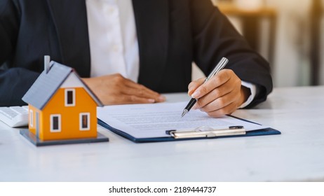 Real Estate Agent Working Sign Agreement Document Contract For Home Loan Insurance Approving Purchases For Client With House Model.