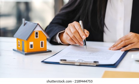 Real Estate Agent Working Sign Agreement Document Contract For Home Loan Insurance Approving Purchases For Client With House Model.