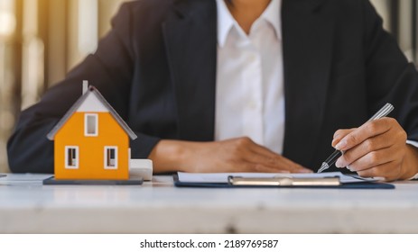 Real Estate Agent Working Sign Agreement Document Contract For Home Loan Insurance Approving Purchases For Client With House Model.