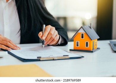 Real Estate Agent Working Sign Agreement Document Contract For Home Loan Insurance Approving Purchases For Client With House Model.