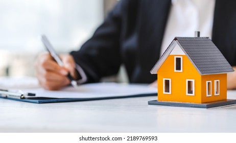 Real Estate Agent Working Sign Agreement Document Contract For Home Loan Insurance Approving Purchases For Client With House Model.