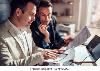 Real Estate Agents Reviewing Rental Contract In The Office