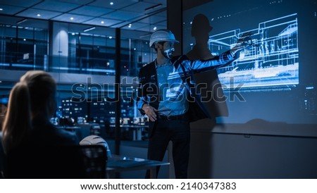 Real Estate Architectural Conference Meeting. Portrait of Chief Architect Presenting Building Construction to Investors. Projector TV Screen in Dark Room Shows 3D Model of Sustainable Housing Project
