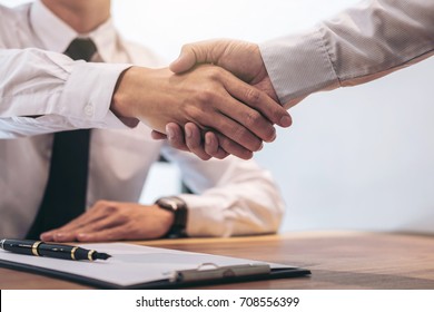 Real estate broker agent   customer shaking hands after signing contract documents for realty purchase  Bank employees congratulate  Concept mortgage loan approval 
