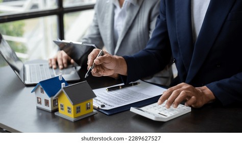 Real estate broker agent presenting and consult to customer to decision making sign insurance form agreement, home model, concerning mortgage loan offer in office - Shutterstock ID 2289627527