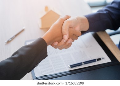 Real estate broker agent Shake hands after customer signing contract document for ownership realty purchase in the office, Business concept and  signing contract - Shutterstock ID 1716355198