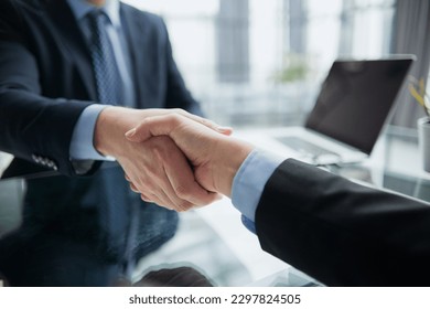 Real estate broker agent Shake hands after customer signing contract document for ownership realty purchase in the office - Shutterstock ID 2297824505