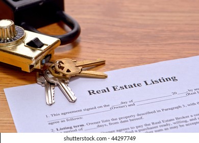 Real Estate Broker Listing Home Seller Document On Realtor Desk With House Keys And Safety Showing Lock Box On Realty Agent Office Desk
