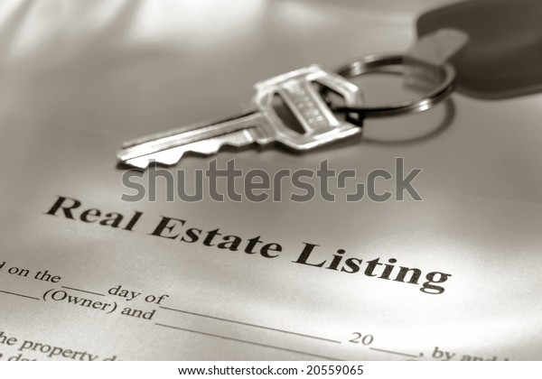 Real estate broker residential\
house sale listing contract paperwork and key on a Realtor\
desk