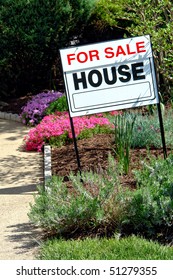 Real Estate Broker For Sale Rider Insert On A Realtor Sign On The Flower Garden In Front Of A House For Sale
