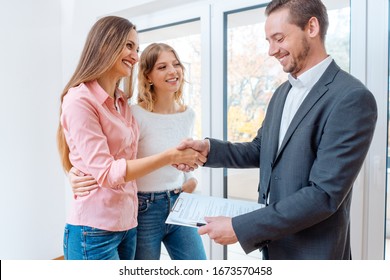 Real estate broker shaking hands with two women tenants