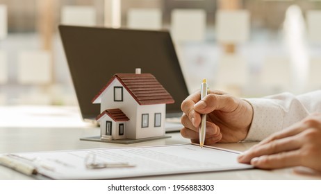 Real Estate Brokerage Contracts For Sale And Rent With A House On The Table In The Office.