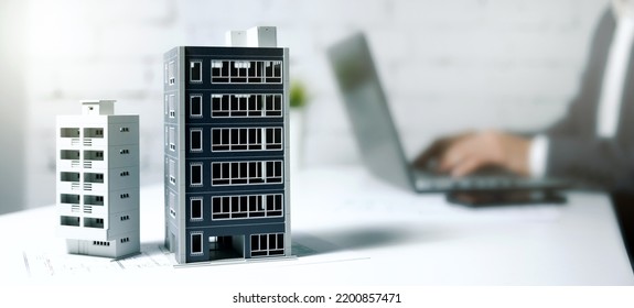 real estate business, housing development, property management. businessman working on laptop in office with building models on table. banner with copy space - Shutterstock ID 2200857471