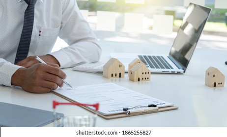 Real Estate Businessman, Home Mortgage Contract, Home Mortgage Loan, Land Collateral With Apartment Building And With Laptop On The Desk In The Office.