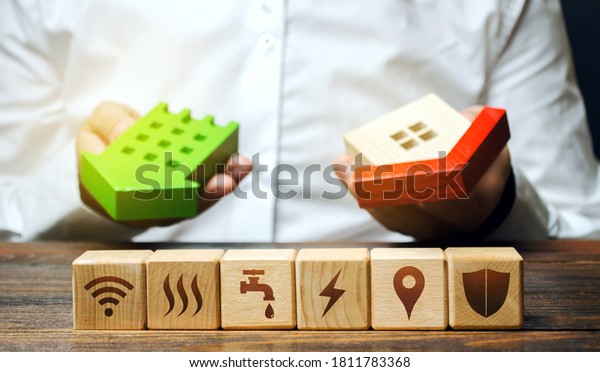 Real estate buyer chooses best option and
blocks with communal services symbols attributes. Utilities public
service. Choosing most economical housing. Reducing costs, saving
energy, natural resources