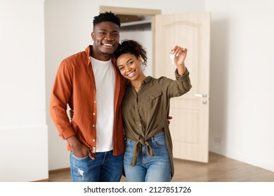 Real Estate. Cheerful African American Spouses Showing New House Key Smiling To Camera, Embracing Standing Among Moving Cardboard Boxes At Home. Relocation, Apartment Ownership And Family Housing - Powered by Shutterstock