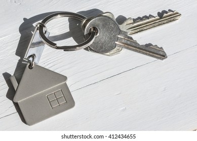 Real Estate Concept. Close Up Of Keys On White Wooden Sunny Background. 