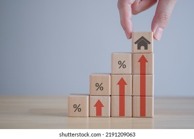 Real estate concept. House, property investment, asset management, Interest rates, loan mortgage, house tax. Hand holding house icon on wooden block from stack of block with percent and rise of arrow. - Shutterstock ID 2191209063