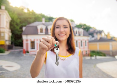 Real Estate. Happy Broker. Attractive Young Woman Holding Keys While Standing Outdoor Against New House.