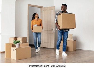 Real Estate. Joyful Black Spouses Holding Cardboard Boxes Entering New House. Family Couple Moving New Home After Relocation. Housing For Young People, Apartment Rent And Purchase. Full Length