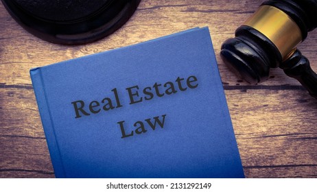 Real Estate Law Book And Gavel On Wooden Table.