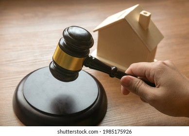 Real Estate Lawyer And House Foreclosure Law With Hand Holding Gavel And House At The Background.