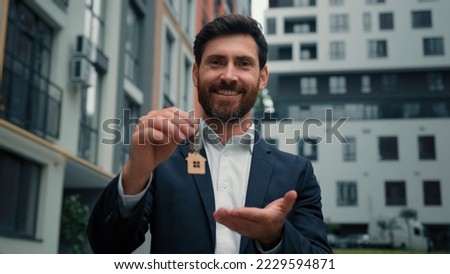 Real estate manager homeowner businessman banker salesman caucasian successful man sell house property hold keys from new apartment in city modern building construction sale commercial business deal