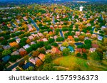 real estate market Aerial drone views above suburb neighborhood community houses and homes multi colored rooftops and fall Autumn seasonal colorful kandscape