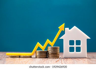 Real estate market, graph, up arrow. House model and a stack of coins. The concept of inflation, economic growth, the price of insurance services