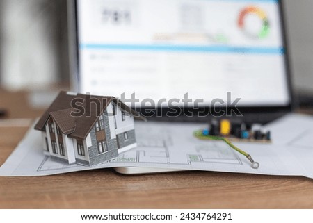 A real estate model and a computer are on the table.