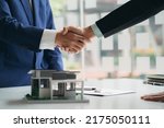 Real estate professionals and clients discussing home purchases, insurance or real estate loans. Home sales agents sit at the office with new homebuyers in the office