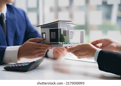 Real estate professionals and clients discussing home purchases, insurance or real estate loans. Home sales agents sit at the office with new homebuyers in the office - Shutterstock ID 2175050093